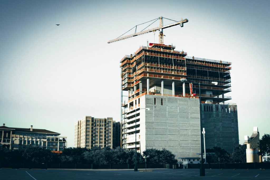 Edifício em construção com guindaste em grande escala, representando gestão de obras de engenharia civil na cidade de Curitiba.