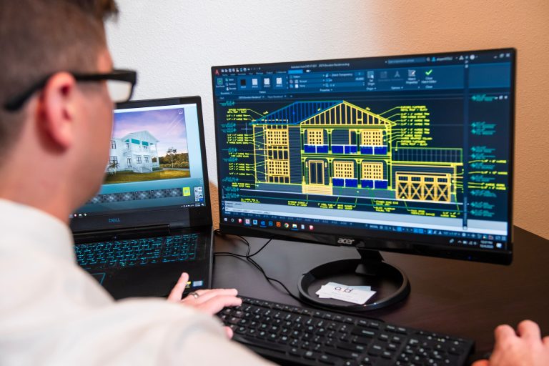 Engenheiro civil utilizando AutoCAD para detalhamento de projeto residencial.
