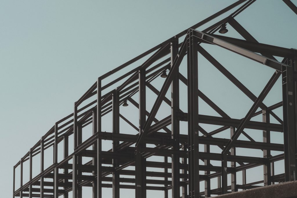 Detalhe da estrutura metálica de um edifício industrial durante a montagem.