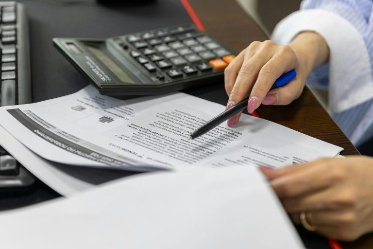 Profissional de engenharia civil analisando documentos técnicos e cálculos de obra.